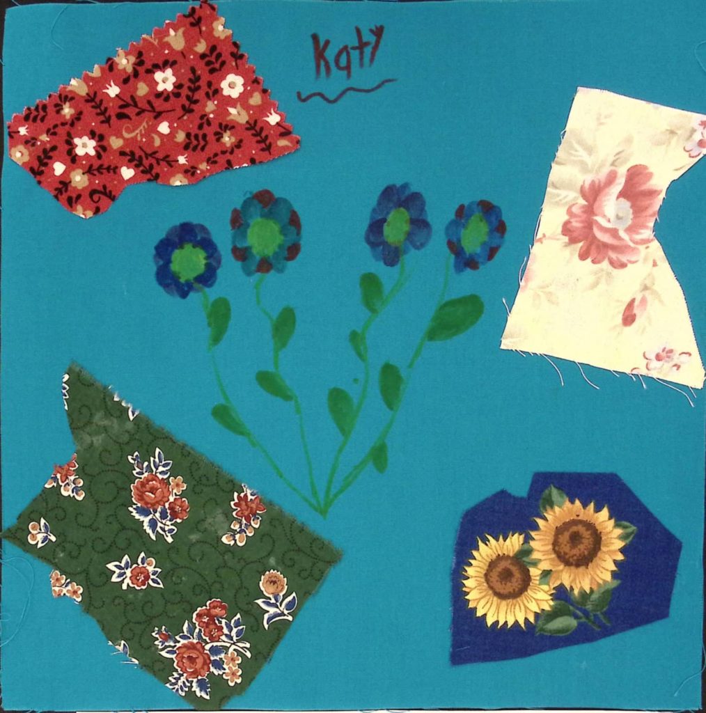 A blue square with flowers and blocks of patterned fabric.