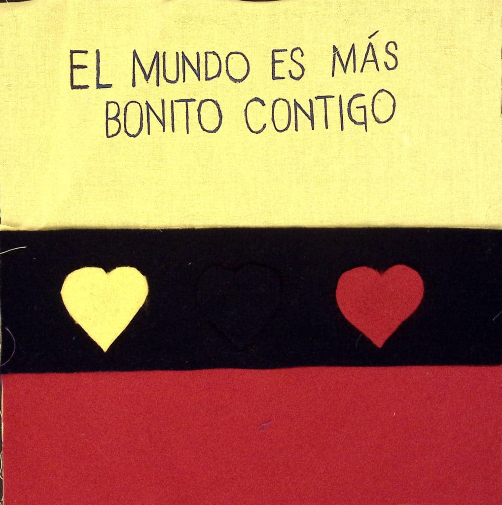 Yellow, dark blue and red stripes with yellow and red heart, and the words "El mundo es mas bonito contigo."