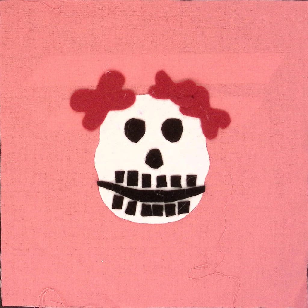 Pink square with a white skull wearing red flowers