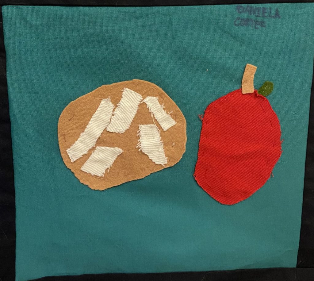 A concha and a red apple on a blue square