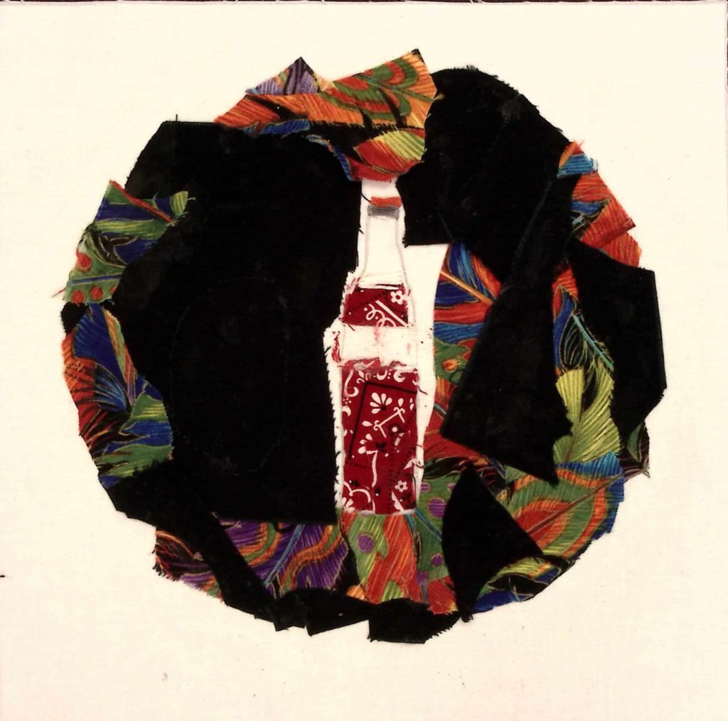 A mostly black circle on white fabric with multicolored fabric mixed in, representing a Coca Cola bottle.