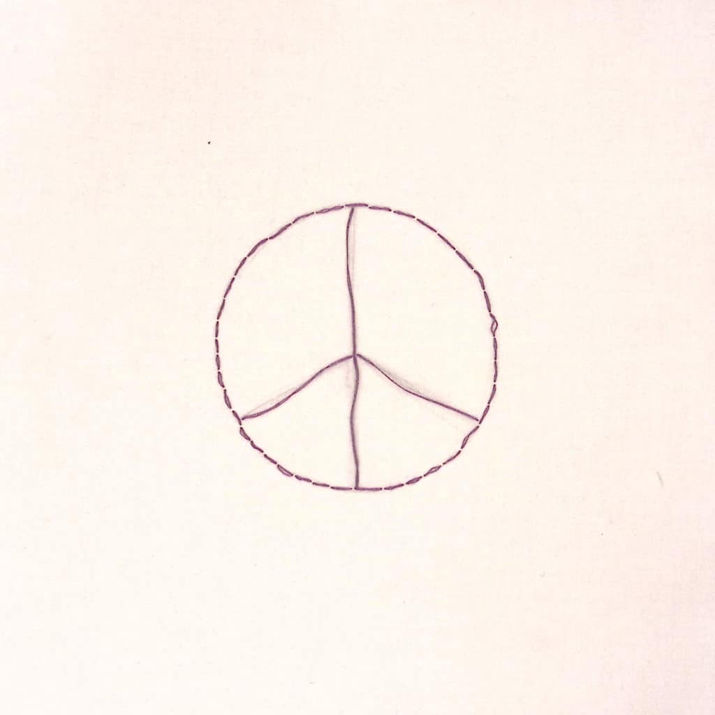 A peace sign embroidered in purple thread on a white background.