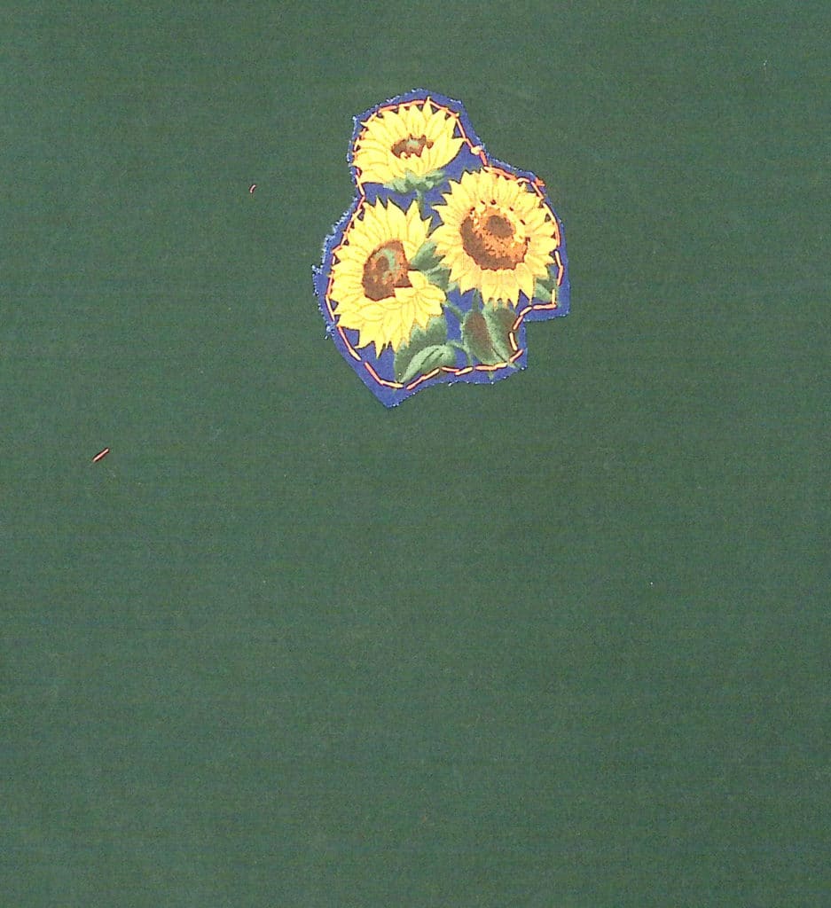 Yellow sunflowers printed on fabric on a green background.