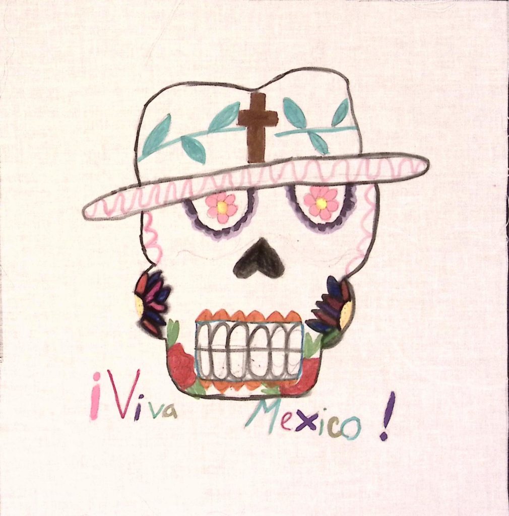 A skull, with colorful flowers in the eyes, on the cheeks, and below the teeth, wearing a wide brimmed hat with a brown cross surrounded in green leaves on it. Under the image, text reads, "!Viva Mexico!"