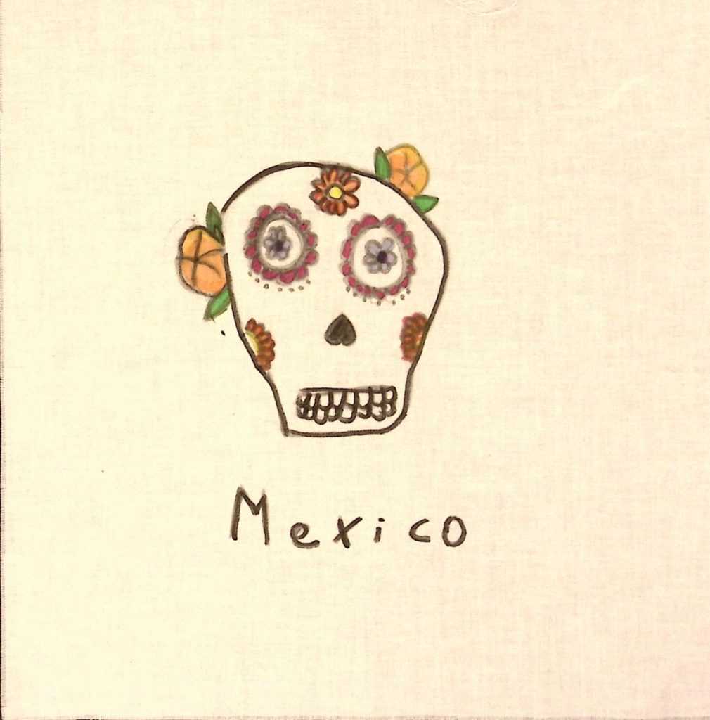 A colorful skull with pink flowers around the eyes, orange flowers on teh cheeks and forheard, with two orange flowrs with green leaves behind. Under, the text reads, "Mexico."
