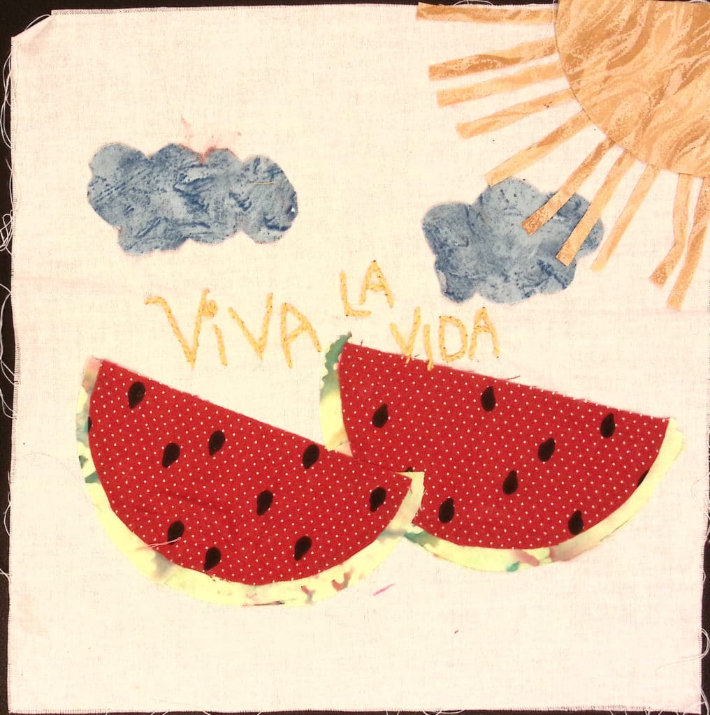 Two fabric watermelon slices with the words "Viva la Vida" with blue clouds and a yellow sun.