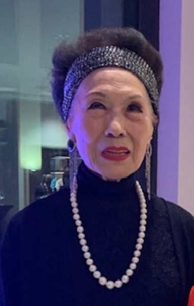 Mae Woo photographed wearing a large pearl necklace.