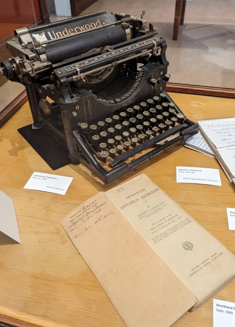 An Underwood typewriter circa 1900, along with a workbook for shorthand dictation exercises from 1909.