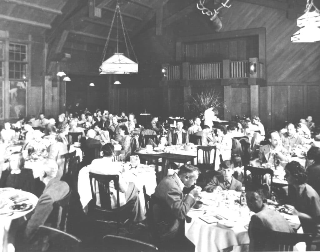 People in the dining room at Aetna Springs resort, seated at tables and eating.