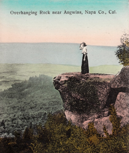 Postcard of a woman standing on an overhanging rock near Angwin, Ca, colorized.