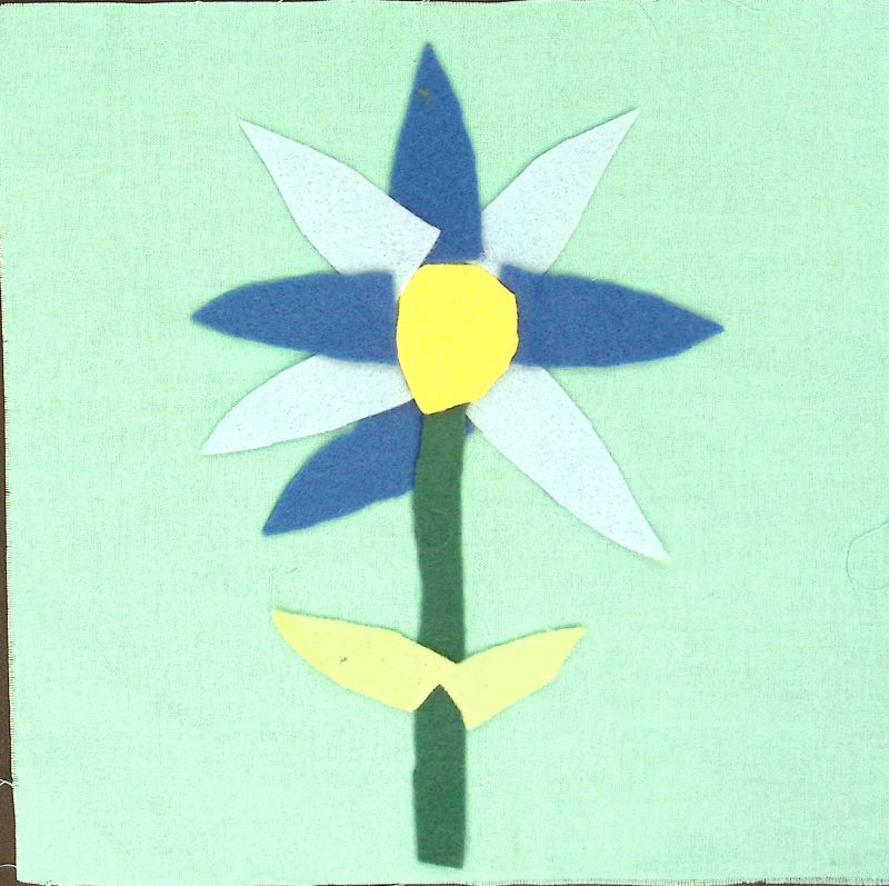 A light blue square with a flower with alternating dark and light blue petals.