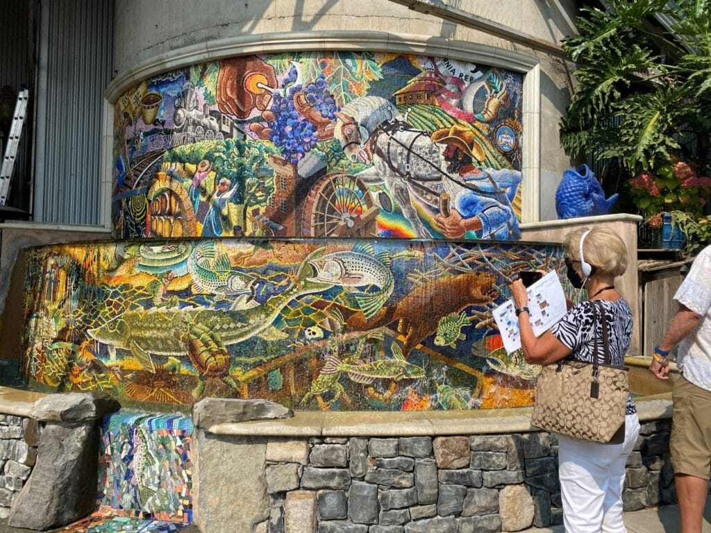 A tour participant stands in front of the mural at Napa River Inn on an NCHS Tour